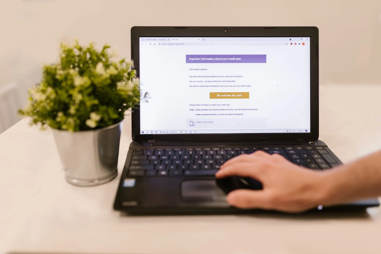 Notebook s podvodným e-mailem a ruka na myši — phishing