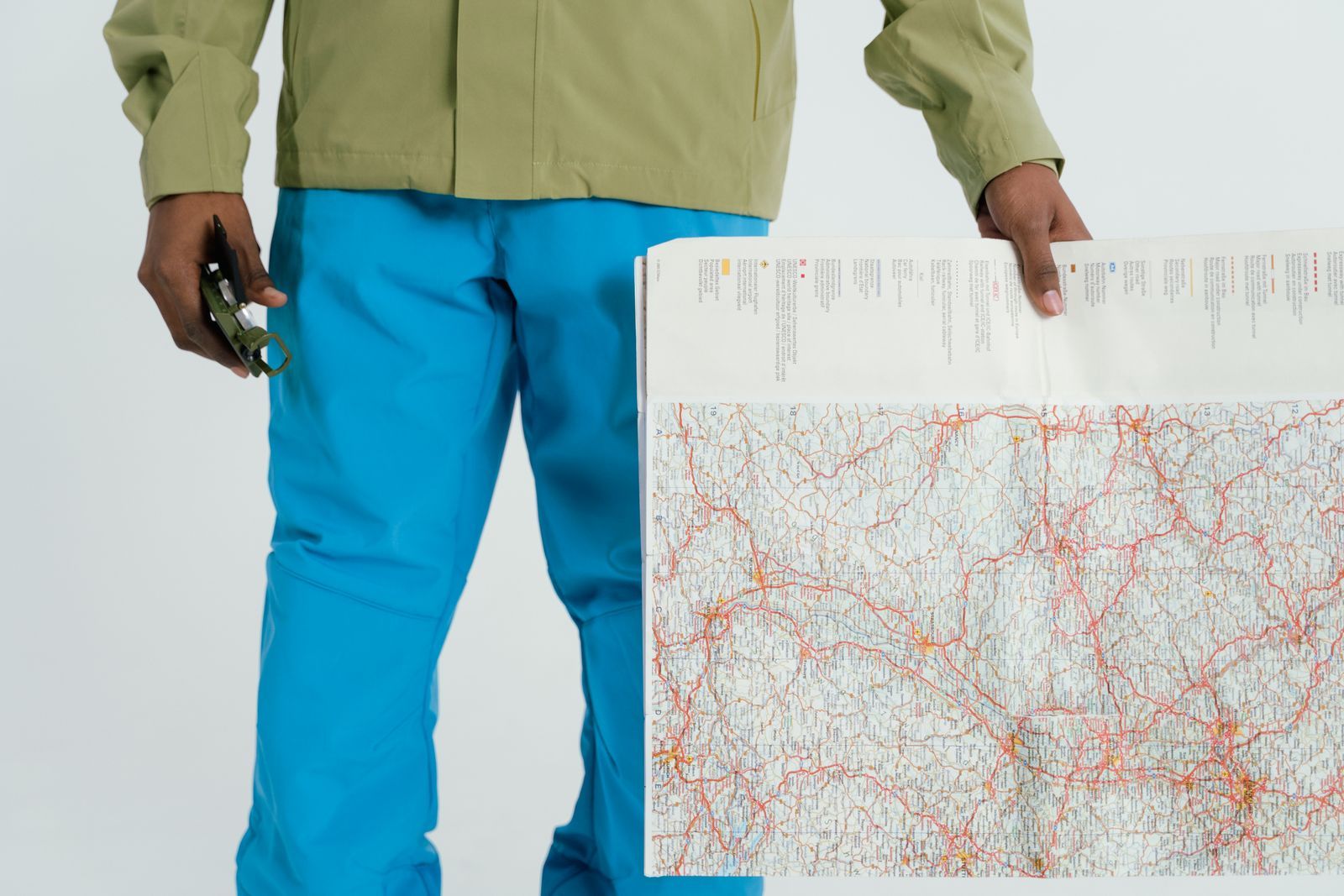 Participant with unfolded map and compass in hand while practicing orientation in the field